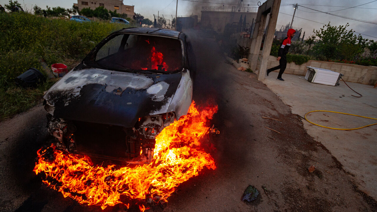 A car belonging to Palestinian villagers set on fire during clashes after the Israeli settlers stormed the village of Qusra in the Israeli-occupied West Bank on Saturday, April 13, 2024. (Photo by Wahaj Bani Moufleh / Middle East Images / Middle East Images via AFP) (Photo by WAHAJ BANI MOUFLEH/Middle East Images/AFP via Getty Images)