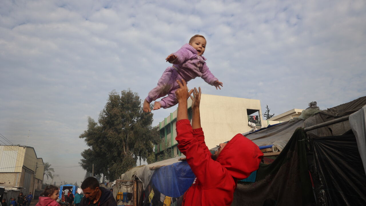 Displaced Palestinians gather outside their tents in Deir al-Balah in the central Gaza Strip on January 16, 2025, one day after the announcement of a ceasefire and hostage release deal between Israel and Hamas to end the 15-month Gaza war. Qatar and the United States announced on January 15 a ceasefire and hostage-release deal between Israel and Hamas that will take effect on the weekend, adding that they hoped it would pave the way for a permanent end to the war in Gaza. (Photo by Eyad BABA / AFP) (Photo b