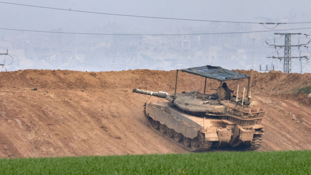 This picture taken from the Israeli side of the border with the Gaza Strip shows an Israeli army tank stationed on a hill overlooking northern Gaza on January 16, 2025, following the announcement of a truce amid the ongoing war between Israel and Hamas. Israel's cabinet was expected to meet on January 16, to approve a ceasefire and hostage-release deal with Hamas, Israeli media reported, a day after mediators announced an agreement they hope will lead to a permanent end to the Gaza war. (Photo by Menahem KA