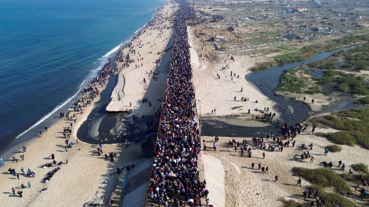 Displaced Gazans walk north along the coast after Israel reopened access to the territory's north on Monday