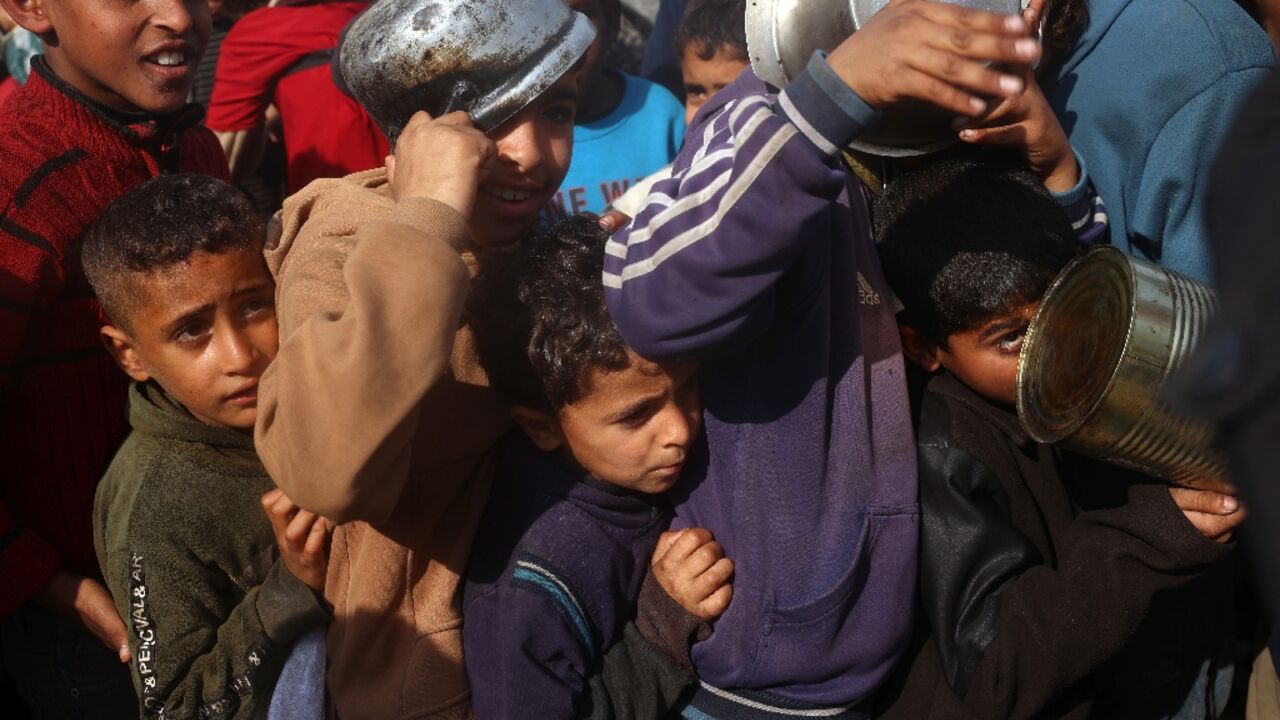 Palestinian children queue for food aid in central Gaza's Deir al-Balah, following the announcement of the truce Palestinian children queue for food aid in central Gaza's Deir al-Balah, following the announcement of the truce