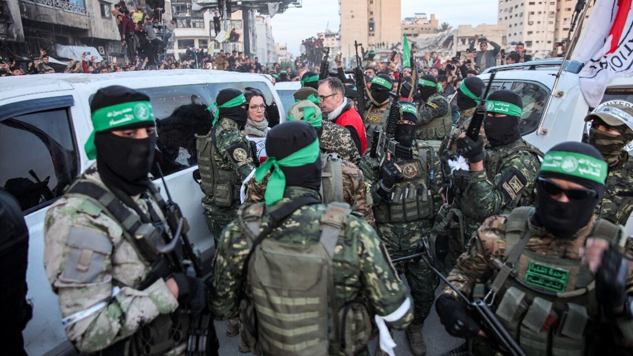 Red Cross officials and Hamas fighters in Gaza City as the first three Israeli hostages are released under a ceasefire deal