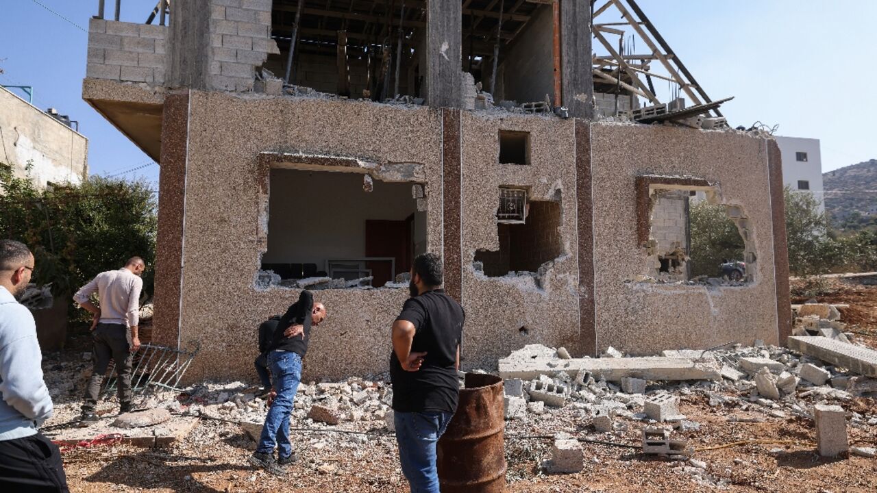 Palestinians inspect the site of an Israeli air strike which killed a man and two children outside their home in the West Bank village of Tammun. Palestinians inspect the site of an Israeli air strike which killed a man and two children outside their home in the West Bank village of Tammun.