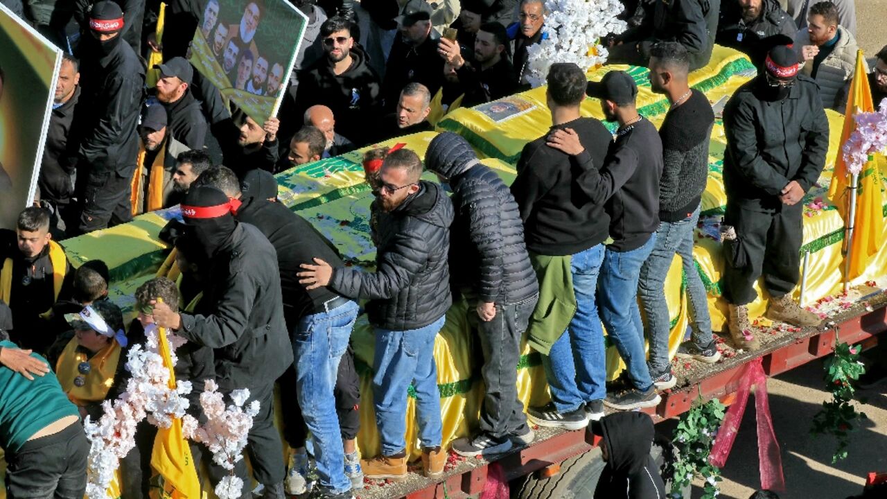 In the heavily damaged town square of Airaroun, southern Lebanon, the coffins arrived on four trucks, some covered in the yellow flag of Iran-backed Hezbollah, others beneath Lebanon's flag.