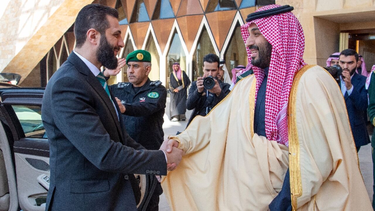 A picture provided by the Saudi Royal Palace shows Crown Prince Mohammed bin Salman welcoming Syria's interim president, Ahmed al-Sharaa