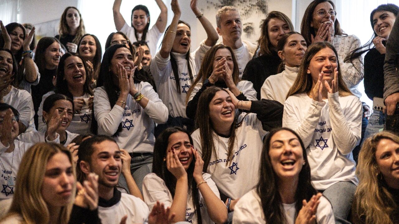 Friends and family of Israeli hostage Omer Shem Tov celebrate as they watch his televised release by Hamas militants at his family home in Tel Aviv