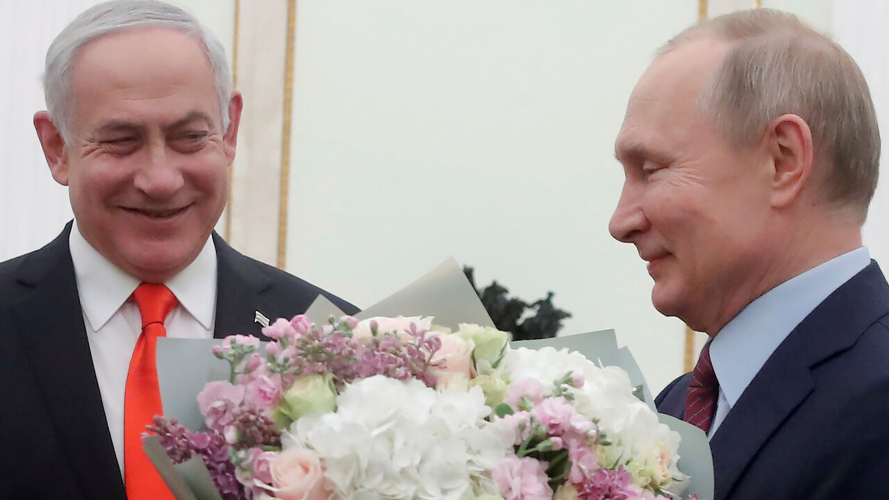 Russian President Vladimir Putin holds flowers next to Israeli Prime Minister Benjamin Netanyahu as they meet at the Kremlin in Moscow on January 30, 2020. (Photo by MAXIM SHEMETOV / POOL / AFP) (Photo by MAXIM SHEMETOV/POOL/AFP via Getty Images)