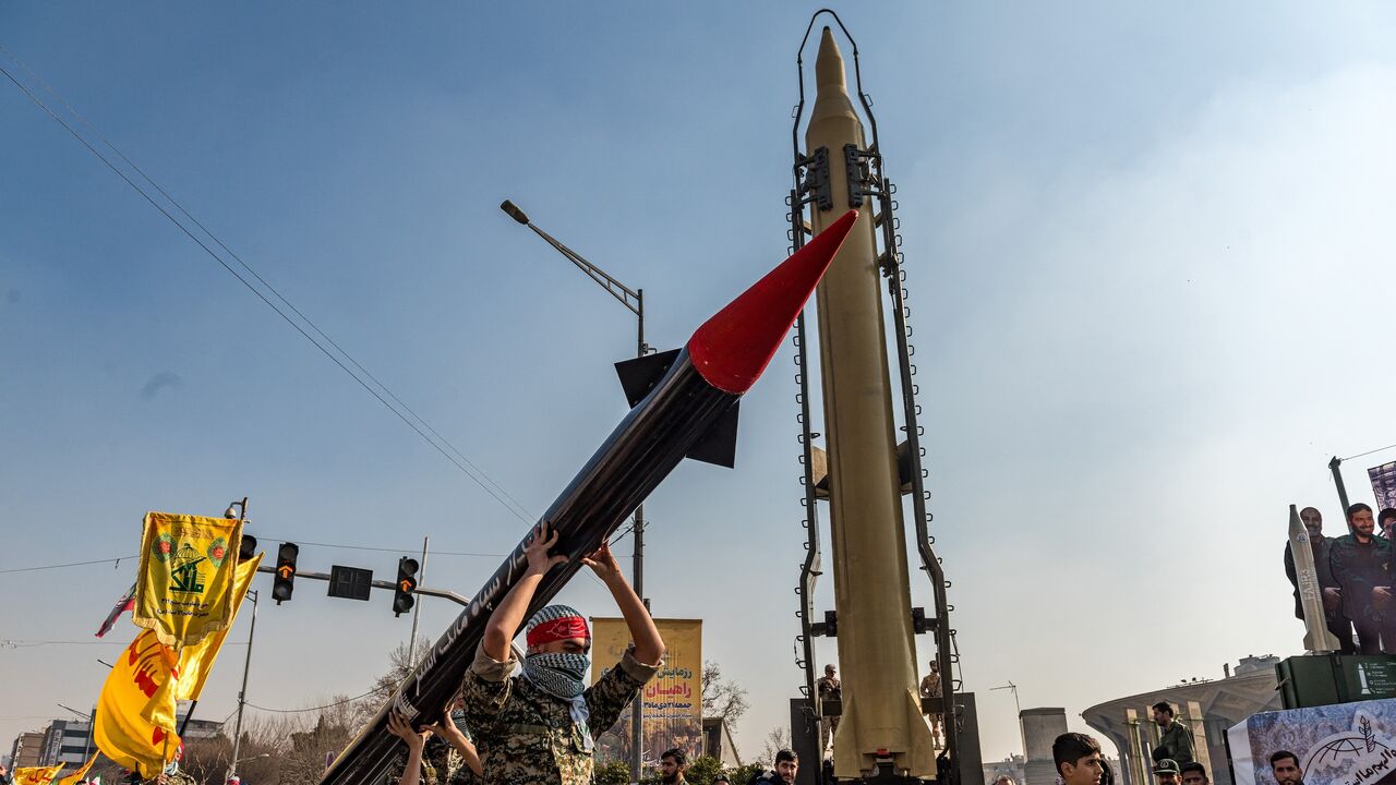 Masked Iranian Basiji men carry a mock up of a missile past the saluting dais during a parade of the paramilitary Basij and IRGC forces in downtown Tehran, Iran, on Jan. 10, 2025.