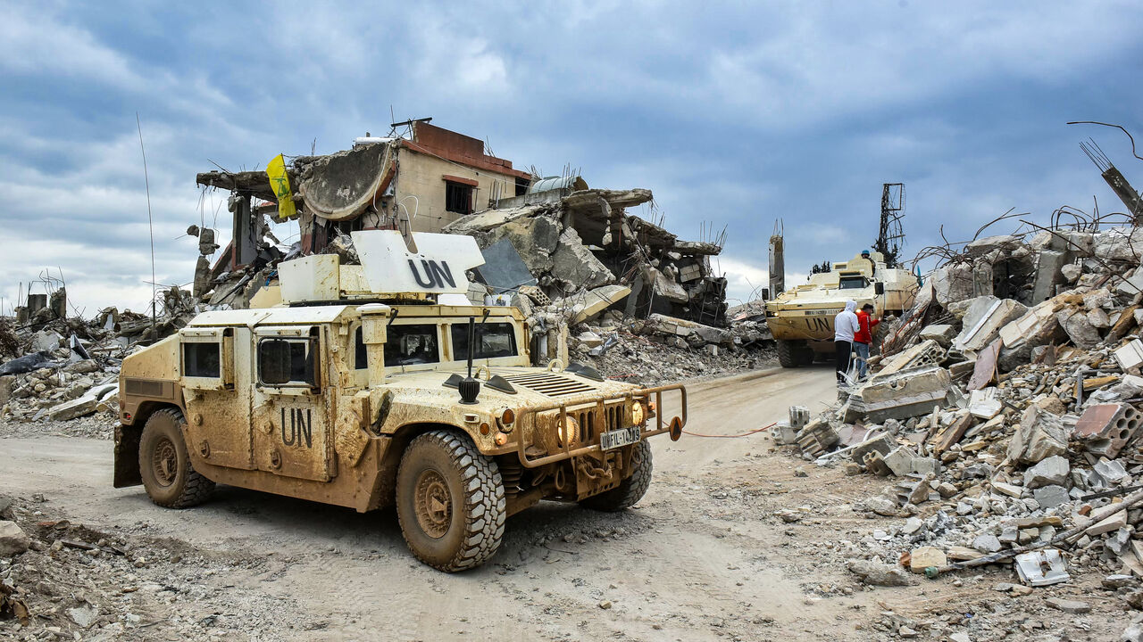 TOPSHOT - UNIFIL vehicles drive past the rubble of destroyed buildings in the southern Lebanese village of Yaroun near the border with Israel on February 19, 2025. Israeli forces withdrew from a series of border villages including southeast Lebanon's Odaisseh, Kfar Kila, Mais al-Jabal, Markaba and Hula under an extended ceasefire deadline that expired on February 18, but remained in five points near the border. (Photo by Fadel ITANI / AFP) (Photo by FADEL ITANI/AFP via Getty Images)