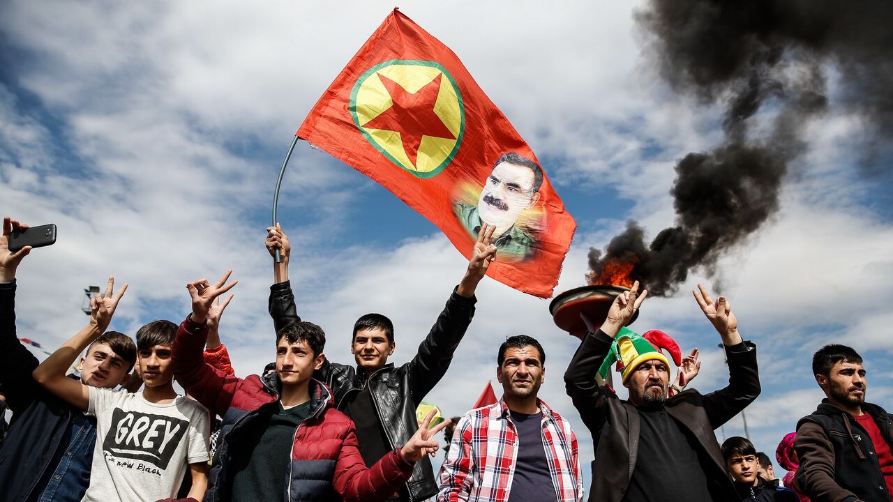  Kurdish men holds up a flag with a picture of the jailed PKK leader Abdullah Ocalan during Newroz celebrations, on March 21, 2015, in Diyarbakir, Turkey