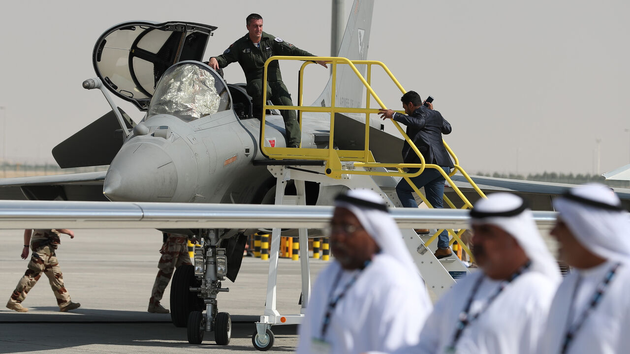 Emiratis walk past a French Rafale fighter jet displayed during the Dubai Airshow on November 14, 2017, in the United Arab Emirates. / AFP PHOTO / KARIM SAHIB (Photo credit should read KARIM SAHIB/AFP via Getty Images)