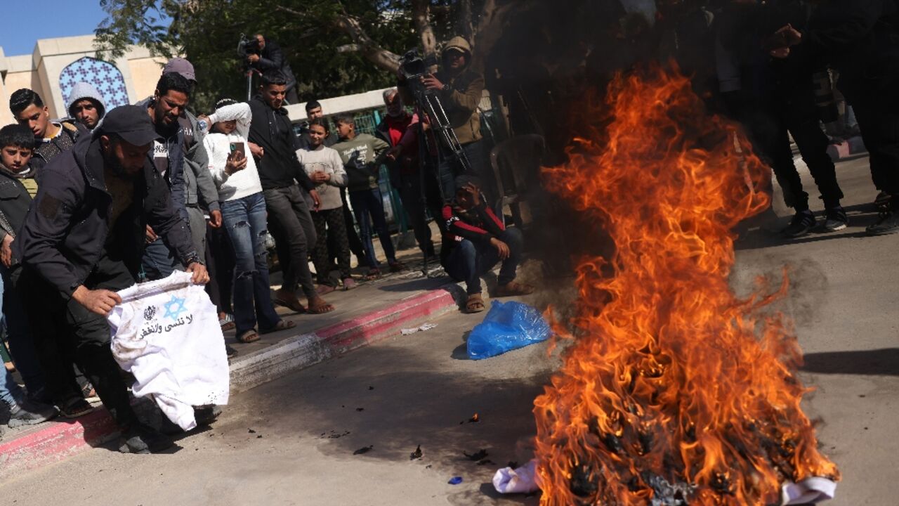 A Palestinian burns a sweatshirt handed to him in Israeli jail, featuring the slogan: "We do not forget and we do not forgive"