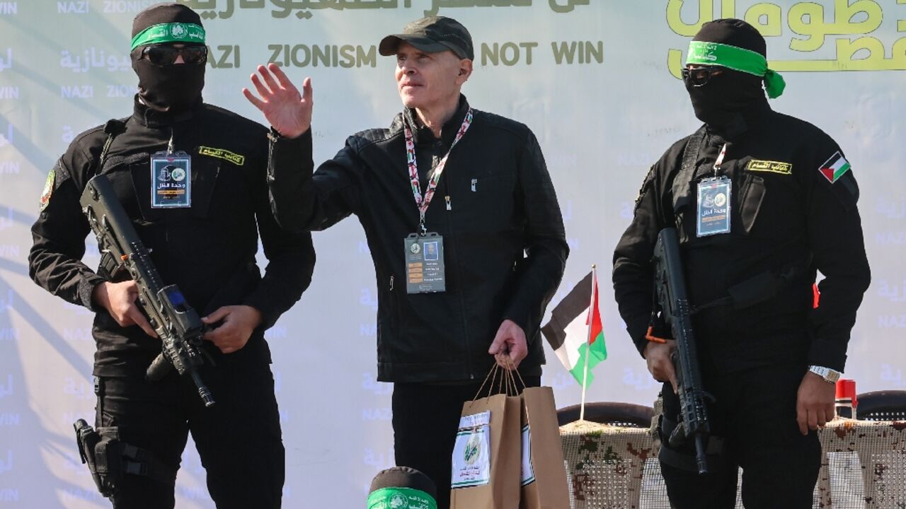 Keith Siegel flanked by Hamas fighters before his handover to the Red Cross