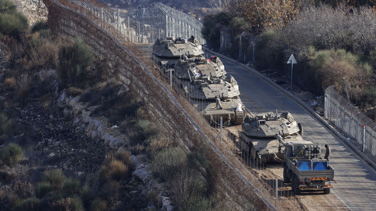 Israeli tanks take position near the fence with the buffer zone that separates the Israeli-annexed Golan Heights from the rest of Syria near the Druze village of Majdal Shams on Dec. 8, 2024. 