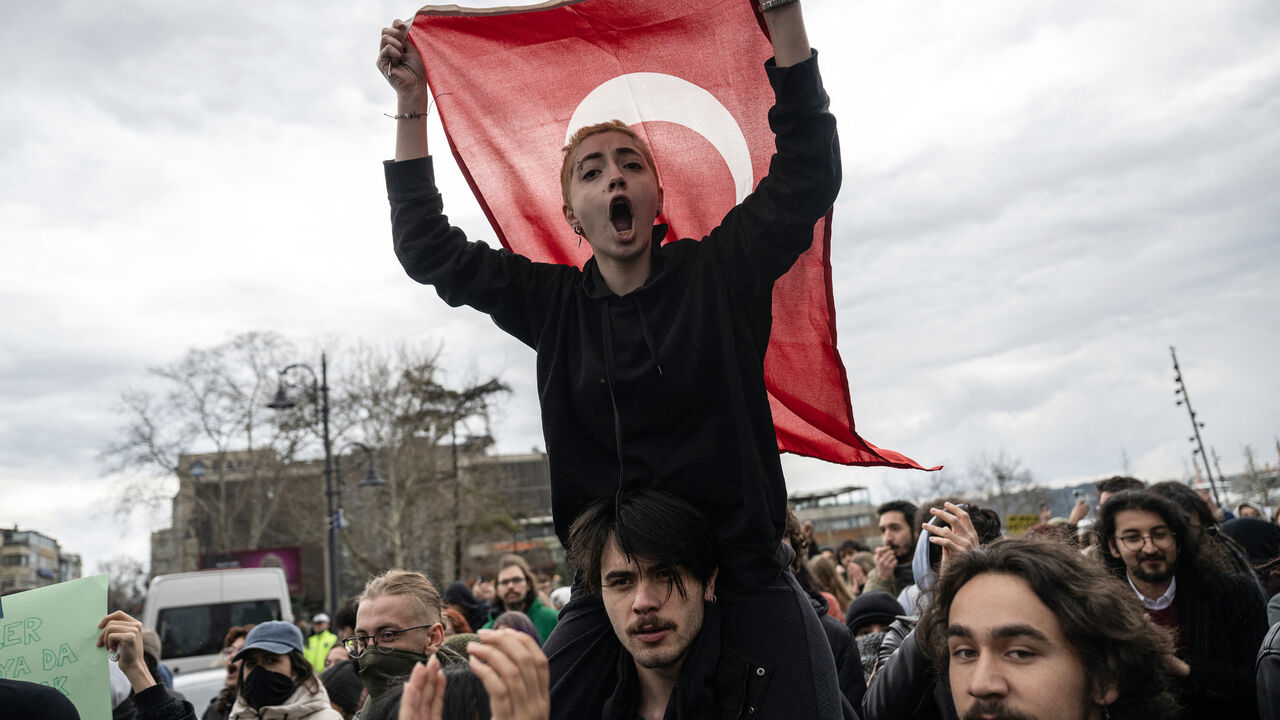 A protester waves a Turkish national flag and chants slogans as university students gather in protest in Besiktas district in Istanbul on March 20, 2025 following Istanbul metropolitan Mayor Ekrem Imamoglu's detention over a corruption probe. Istanbul's powerful mayor, Ekrem Imamoglu, remained in police custody on March 20, 2025 over graft and terror allegations after being held the day before, as his party called for more protests in Turkey's largest city. (Photo by Ozan KOSE / AFP) (Photo by OZAN KOSE/AFP