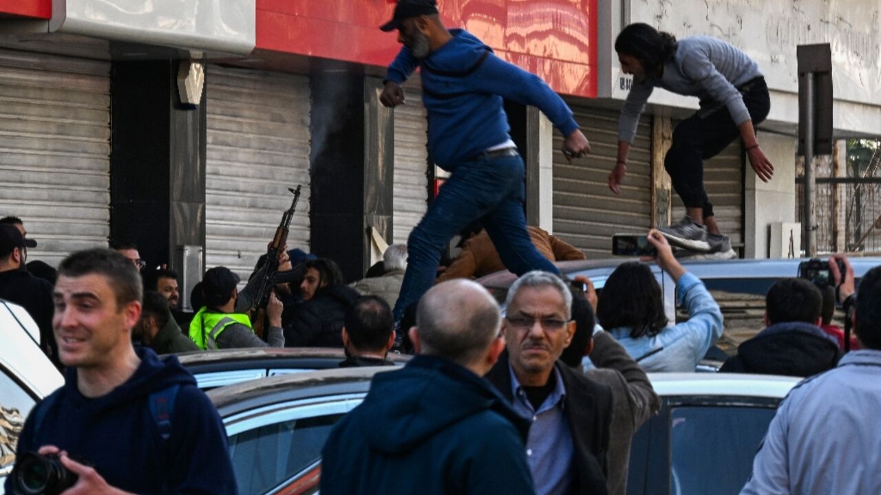 A gunman fires shots in the air to disperse clashing protesters in Syria's capital Damascus, after reported mass killings of the minority Alawite community