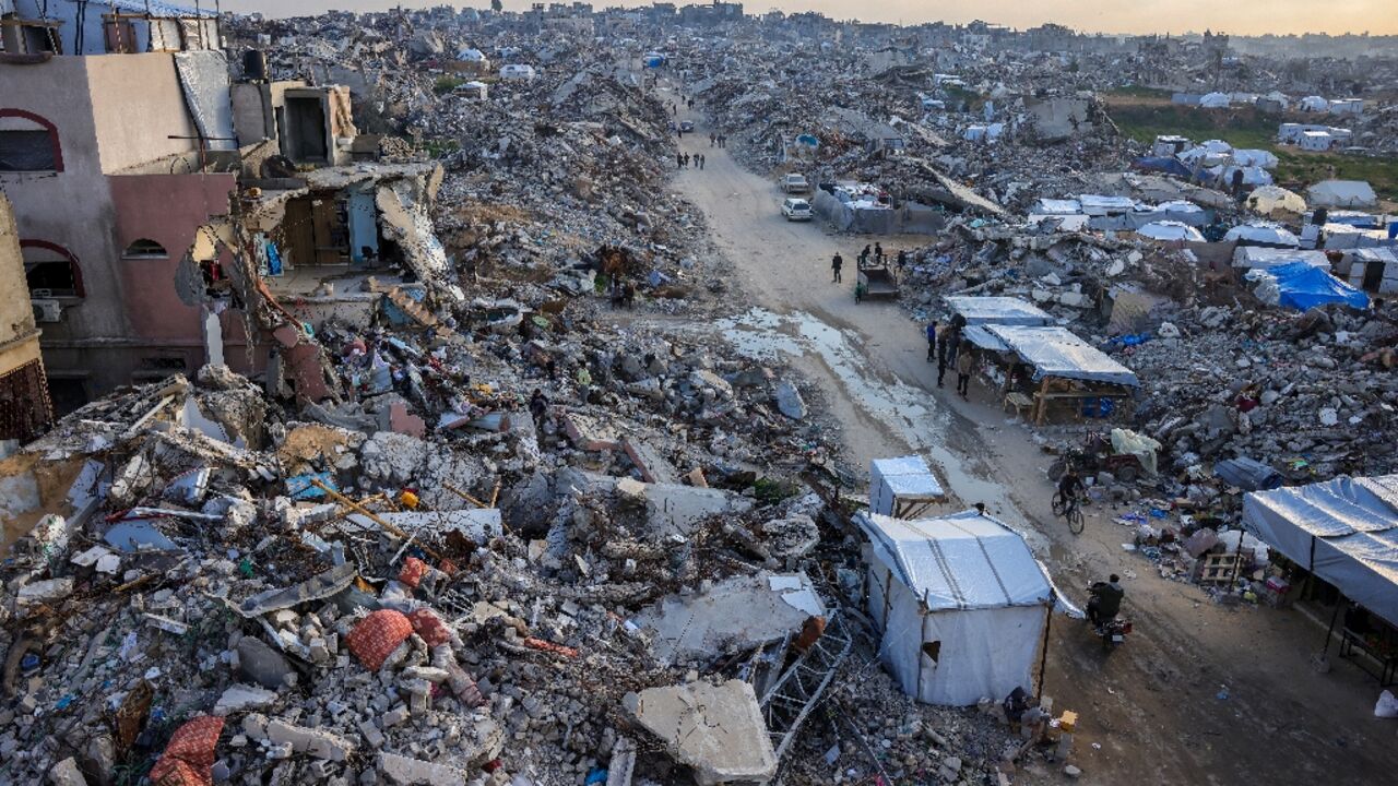 Palestinians walk amid the rubble of buildings in Beit Lahia, northern Gaza Palestinians walk amid the rubble of buildings in Beit Lahia, northern Gaza
