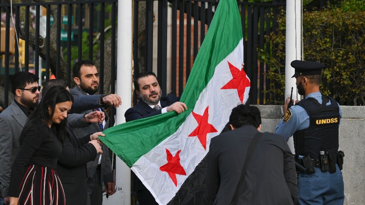 Syrian Foreign Minister Asaad al-Shaibani raises the new Syrian flag during a ceremony at United Nations headquarters in New York Syrian Foreign Minister Asaad al-Shaibani raises the new Syrian flag during a ceremony at United Nations headquarters in New York