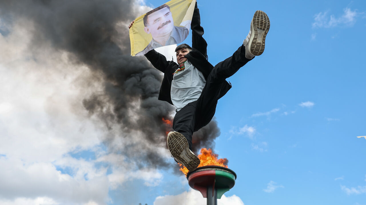 DIYARBAKIR, TURKEY - MARCH 21: A young man jumps holding poster of the jailed PKK militant group leader Abdullah Ocalan during Newroz celebrations on March 21, 2025 in Diyarbakir, Turkey. Newroz, or Nowruz, a celebration of the spring equinox and Persian new year, is observed by a diverse array of communities across western and central Asia, including Kurdish areas of Turkey, Syria and Iraq. Newroz is the most important festival in Kurdish culture and has taken the form of political expression among Kurds i