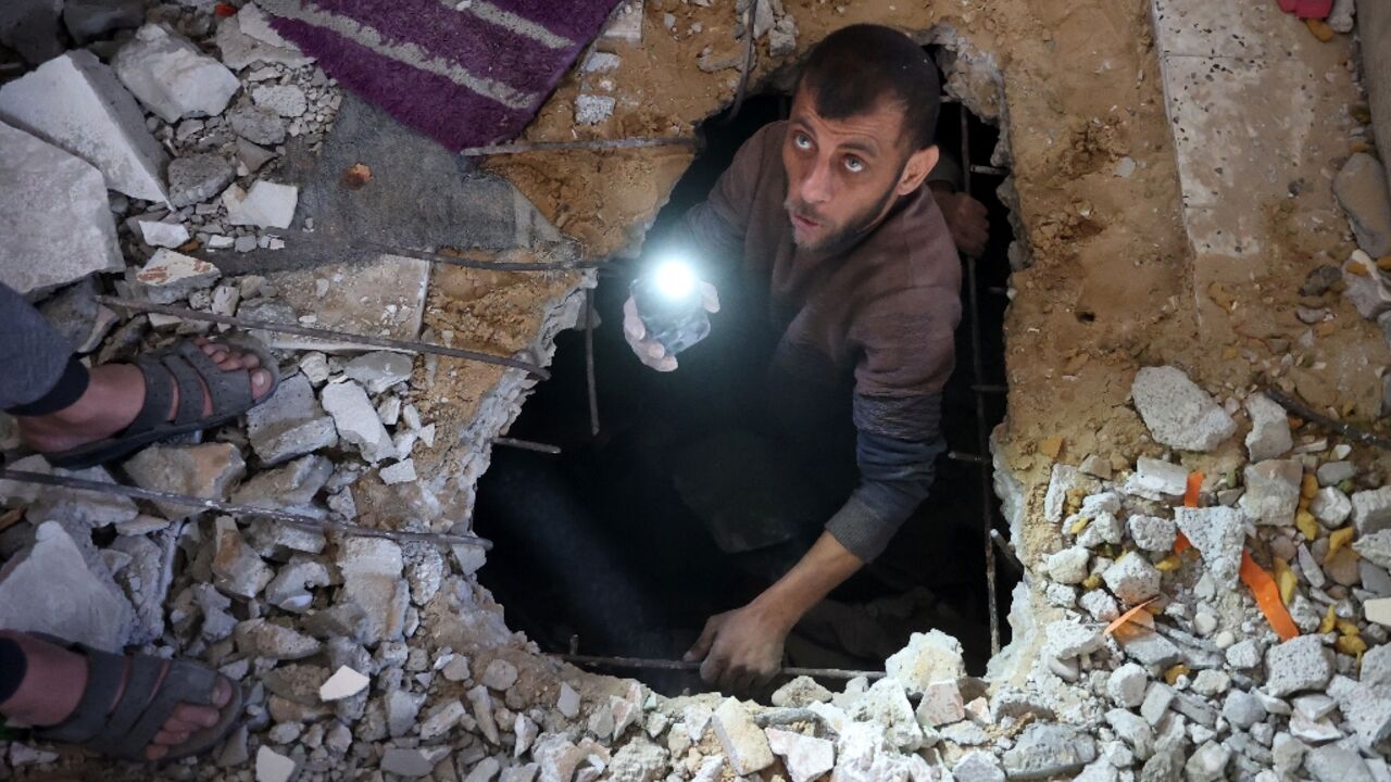 A man searches for victims or survivors amid the rubble of a house hit in a strike on Gaza City A man searches for victims or survivors amid the rubble of a house hit in a strike on Gaza City