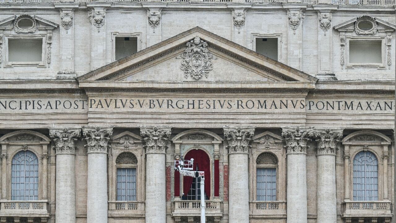 A worker prepares the main central balcony of St Peter's basilica A worker prepares the main central balcony of St Peter's basilica