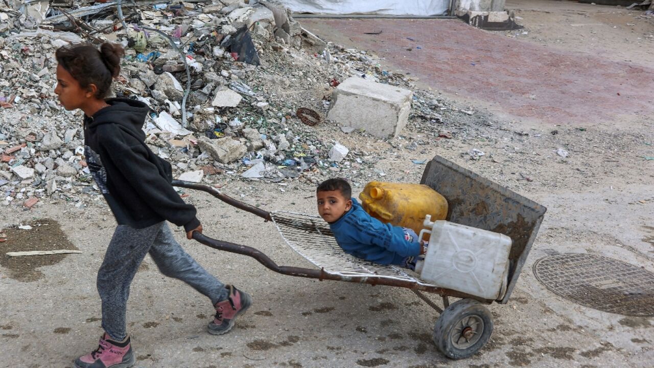 Palestinian children head to a water distribution point to fill their containers in Gaza City Palestinian children head to a water distribution point to fill their containers in Gaza City