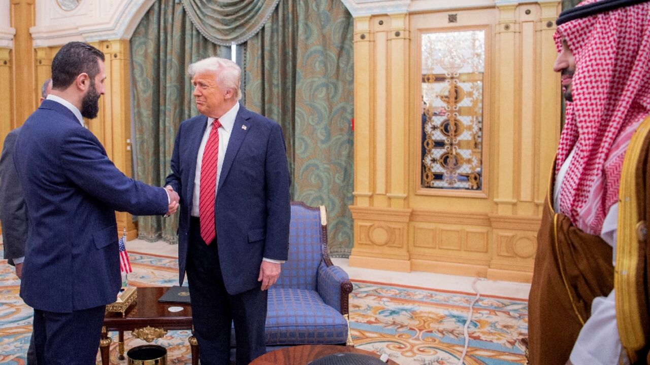 Saudi Crown Prince Mohammed bin Salman watches as US President Donald Trump (C) shakes hands with Syria's interim president Ahmed al-Sharaa in Riyadh Saudi Crown Prince Mohammed bin Salman watches as US President Donald Trump (C) shakes hands with Syria's interim president Ahmed al-Sharaa in Riyadh