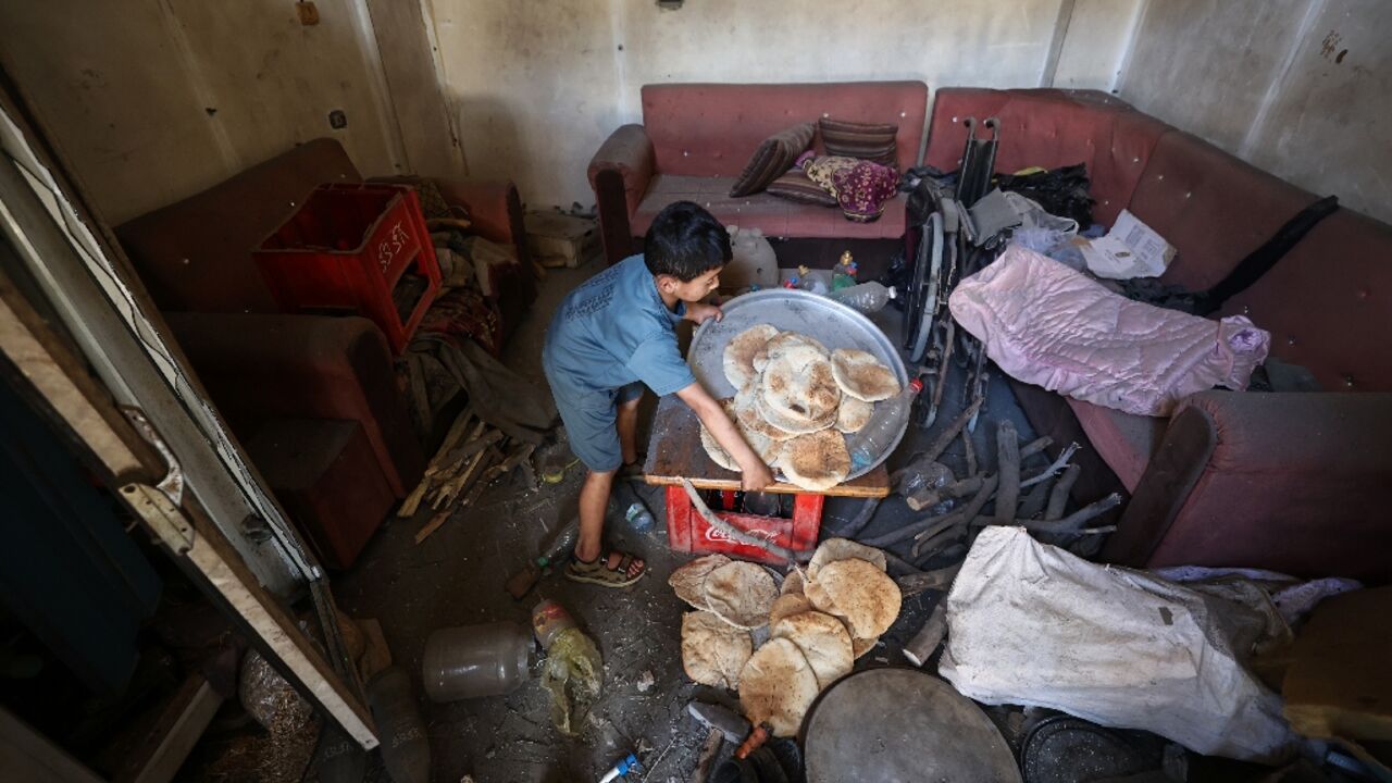 A Palestinian boy salvages bread from a makeshift bakery hit by Israeli strikes at the Nuseirat refugee camp in central Gaza A Palestinian boy salvages bread from a makeshift bakery hit by Israeli strikes at the Nuseirat refugee camp in central Gaza