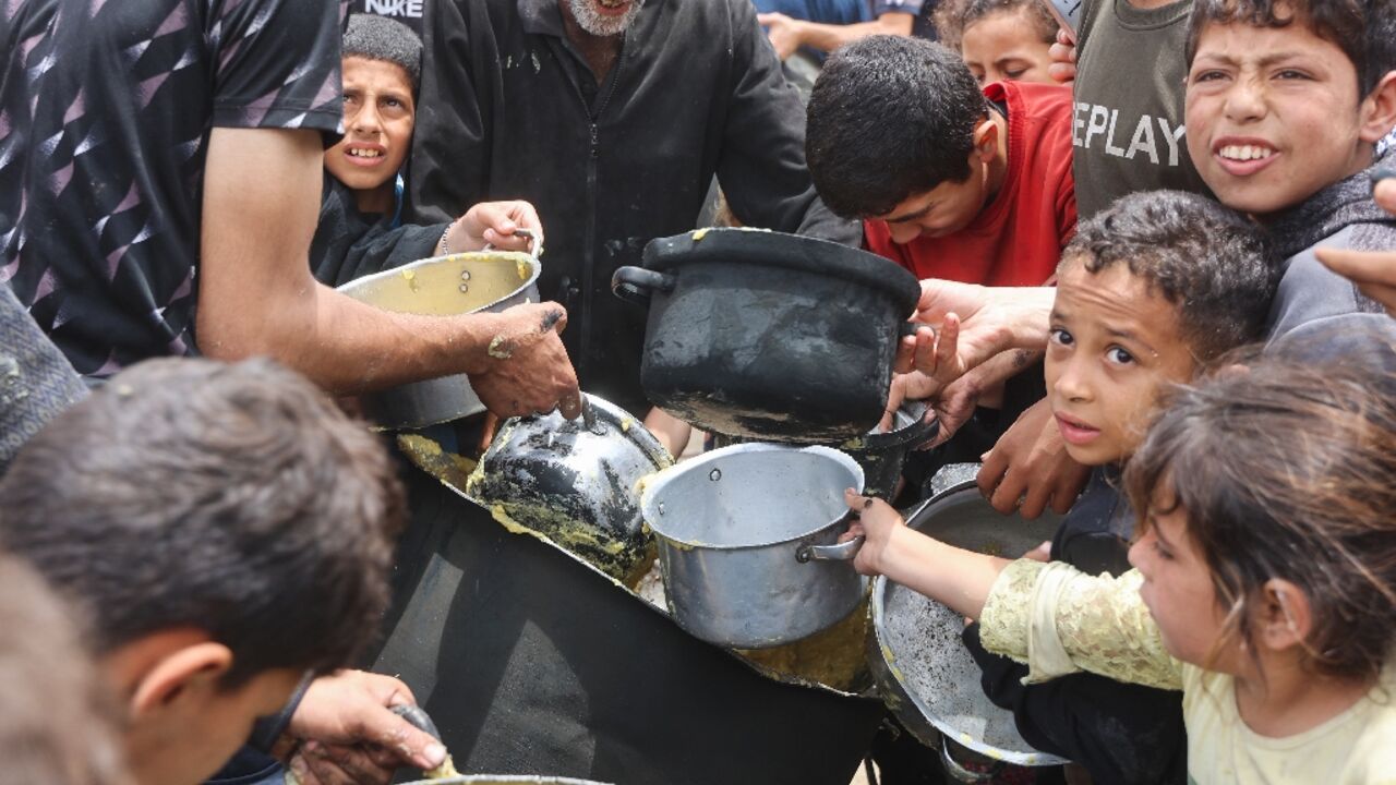 Palestinian children getting a hot food ration from a charity kitchen at the Islamic University campus in Gaza City Palestinian children getting a hot food ration from a charity kitchen at the Islamic University campus in Gaza City