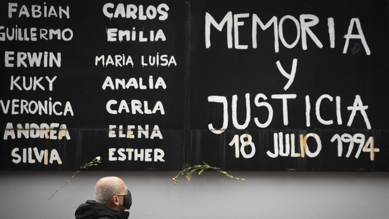 A man pays tribute during the commemoration of the 26th anniversary of a bomb attack