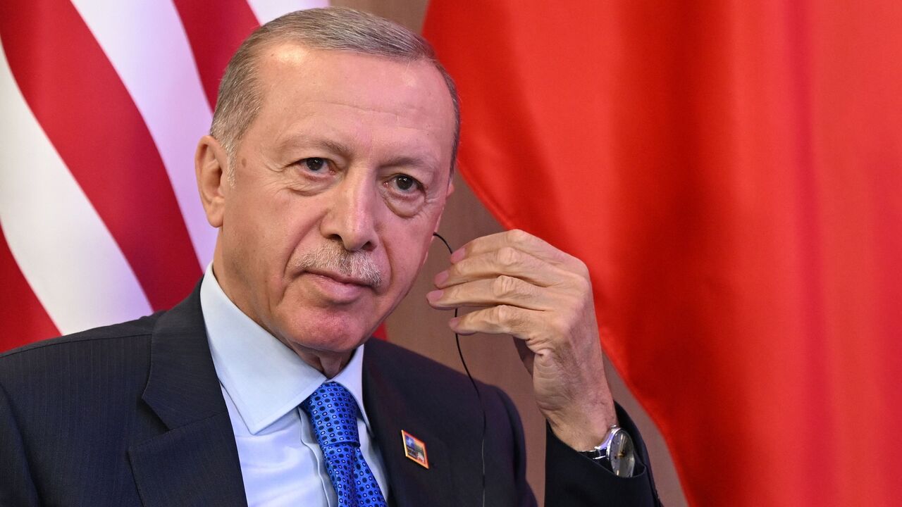 Turkey's President Recep Tayyip Erdogan looks adjusts his earpiece during bilateral talks with the US President the NATO Summit in Vilnius on July 11, 2023.
