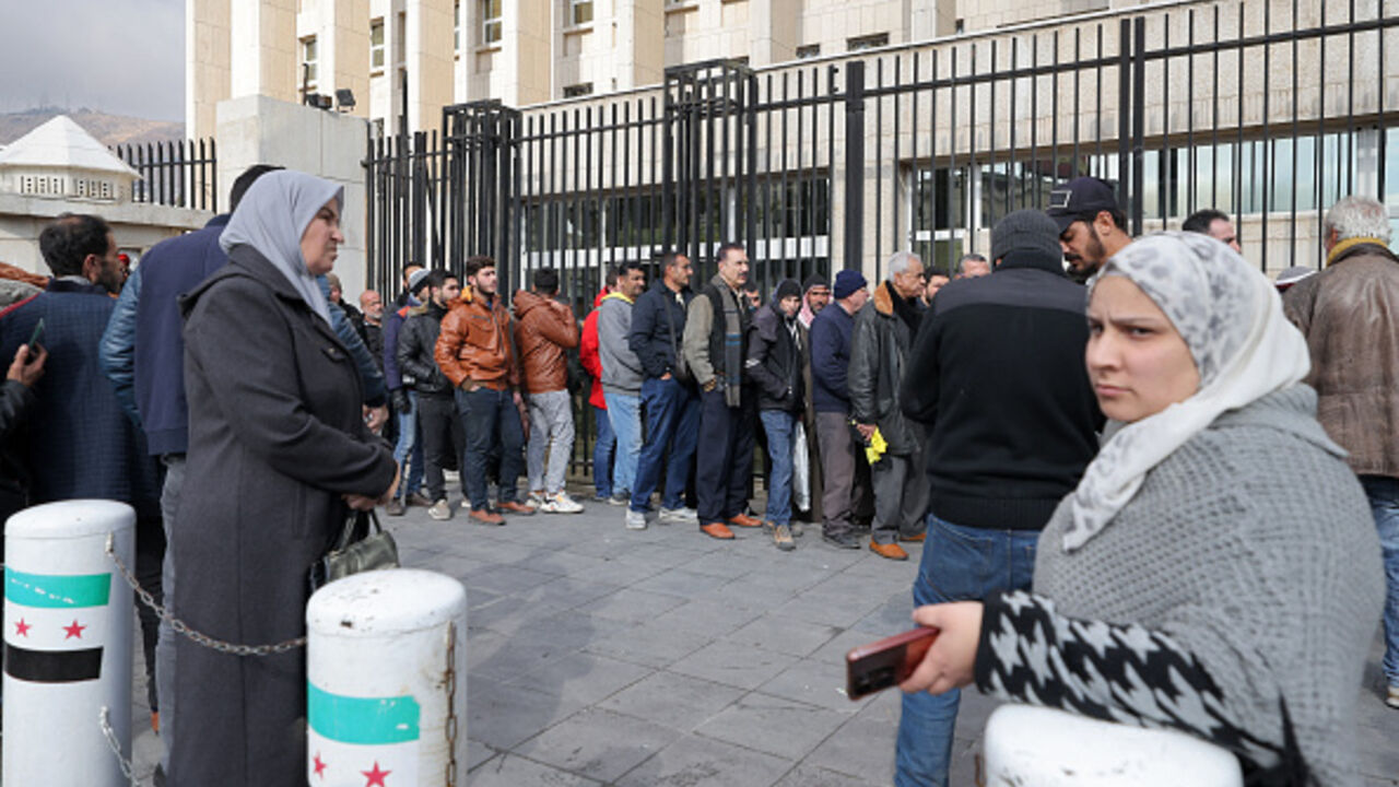 People queue outside the main headquarters of the Central Bank of Syria to exchange US dollars at prices lower than the black market, in Damascus on December 30, 2024. (Photo by ANWAR AMRO / AFP) (Photo by ANWAR AMRO/AFP via Getty Images)
