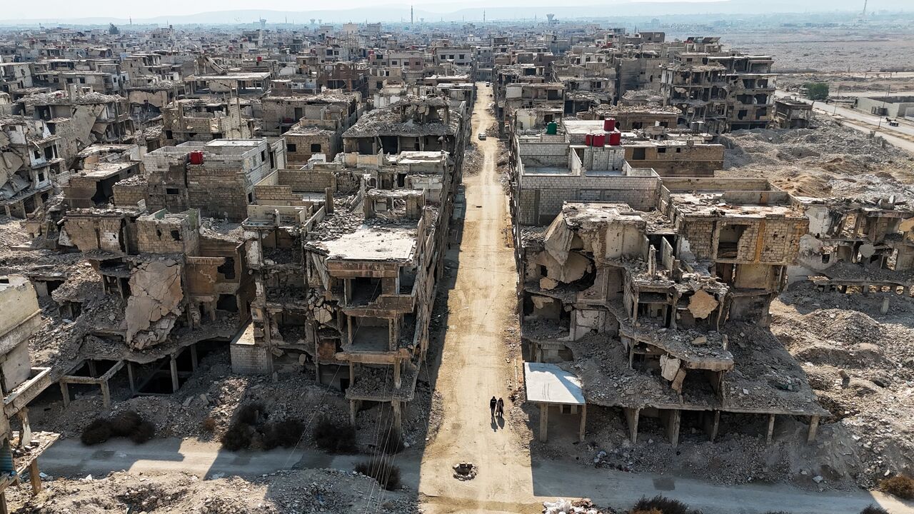 A couple walk through the remains of the Yarmouk refugee camp, Syria’s largest Palestinian refugee camp, Damascus, Jan. 27, 2025.