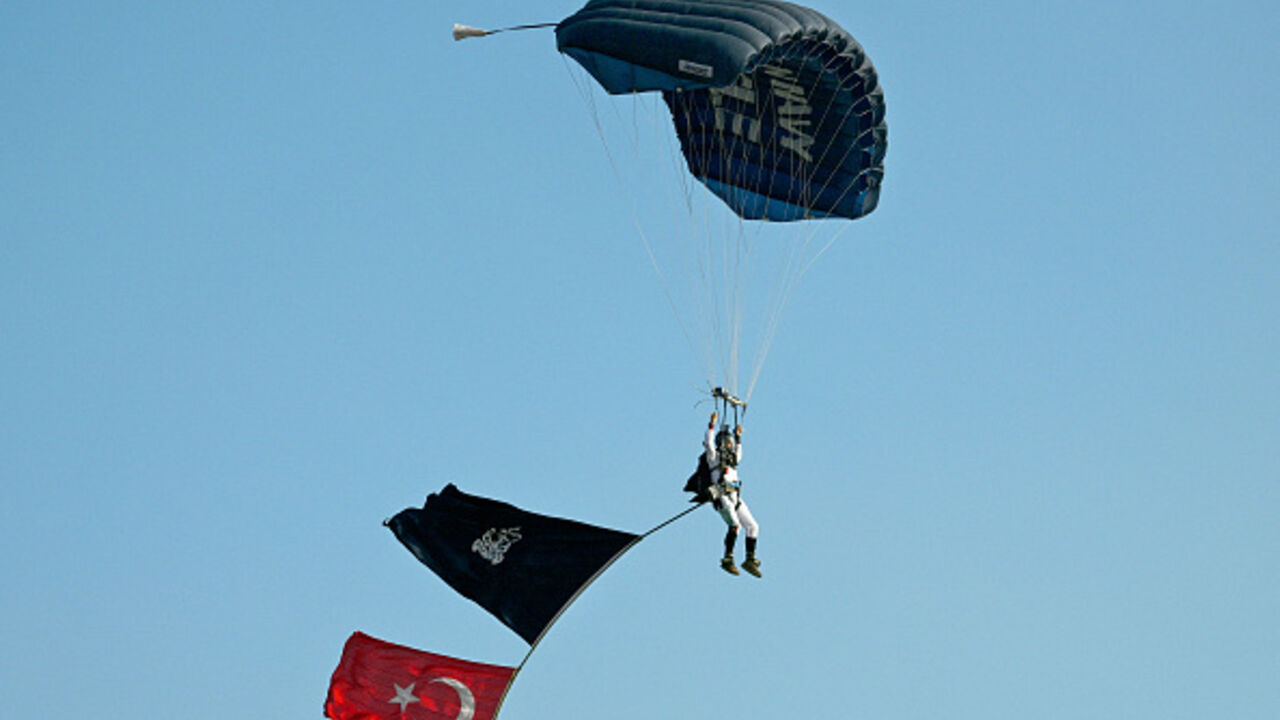 A paratrooper of the Pakistan Navy Special Service Group unfurls the Pakistan Navy flag and the national flag of Turkey during a multinational naval exercise in Karachi on February 9, 2025. (ASIF HASSAN/AFP via Getty Images)