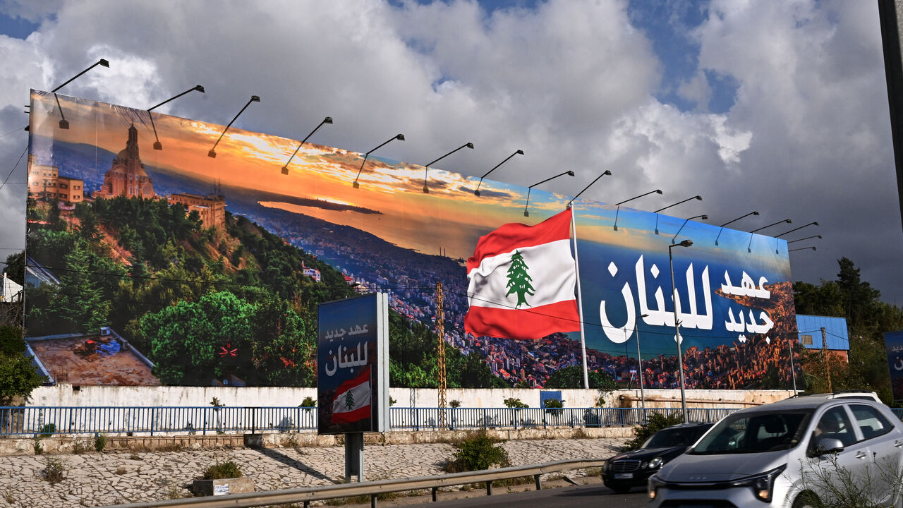 Commuters drive past a newly-installed billboard bearing the image of a Lebanese flag and a statement that reads in Arabic "Lebanon a new era", replacing a Hezbollah billboard, on the road leading to Beirut's Rafic Hariri International airport on April 10, 2025. (Photo by JOSEPH EID / AFP) (Photo by JOSEPH EID/AFP via Getty Images)