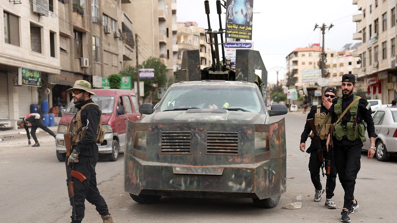 Members of Syria's security forces stand guard at a checkpoint in Ashrafiyat Sahnaya, near Damascus, after days of deadly sectarian clashes involving the Druze, May 1, 2025.