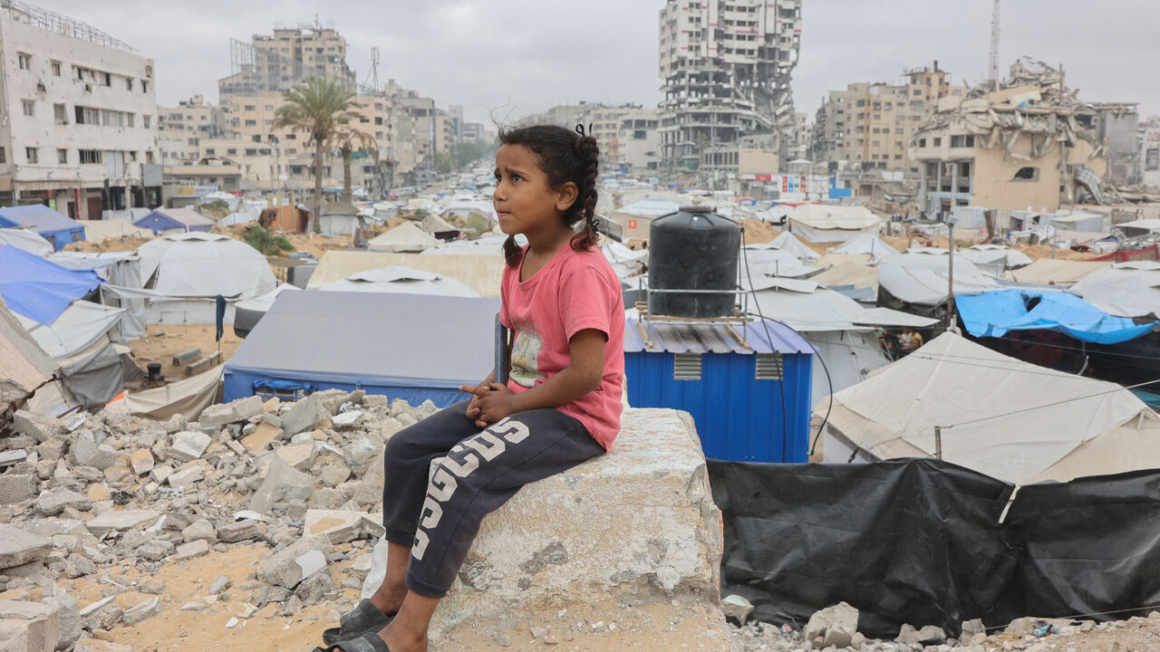 A Palestinian girl sits amid a makeshift displacement camp set up amid building rubble in Gaza City on May 12, 2025. Israeli Prime Minister Benjamin Netanyahu said on May 12 that the release of a US-Israeli hostage announced by Hamas would not lead to a ceasefire in the Gaza Strip or the release of Palestinian detainees. (Photo by Omar AL-QATTAA / AFP) (Photo by OMAR AL-QATTAA/AFP via Getty Images)