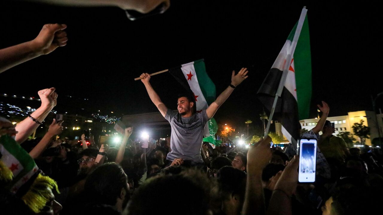 People celebrate in Damascus' Omeyyad square after US President Donald Trump's decision to lift sanctions in Syria, on May 13, 2025