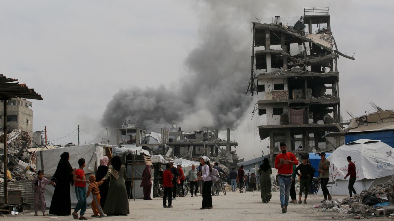 Palestinians react as an Israeli strike hits the home (L) of the Hmeid family in Jabalia, in the northern Gaza Strip, May 15, 2025.