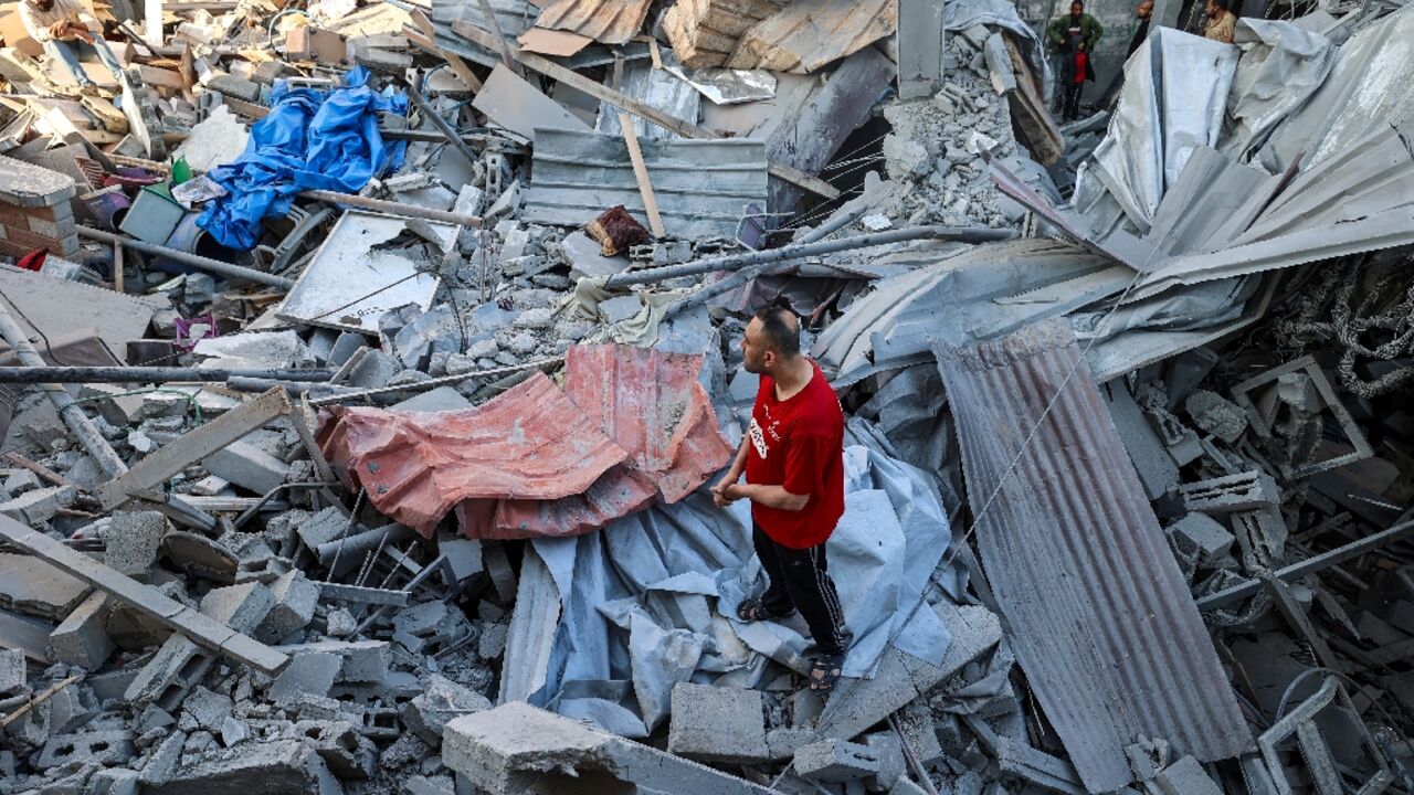 A man stands on the rubble of a building hit in an Israeli strike in the Bureij camp for Palestinian refugees in the central Gaza Strip A man stands on the rubble of a building hit in an Israeli strike in the Bureij camp for Palestinian refugees in the central Gaza Strip