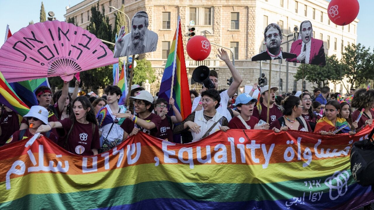 Participants march with a giant pride flag during the annual Jerusalem Pride Parade in the city centre Participants march with a giant pride flag during the annual Jerusalem Pride Parade in the city centre
