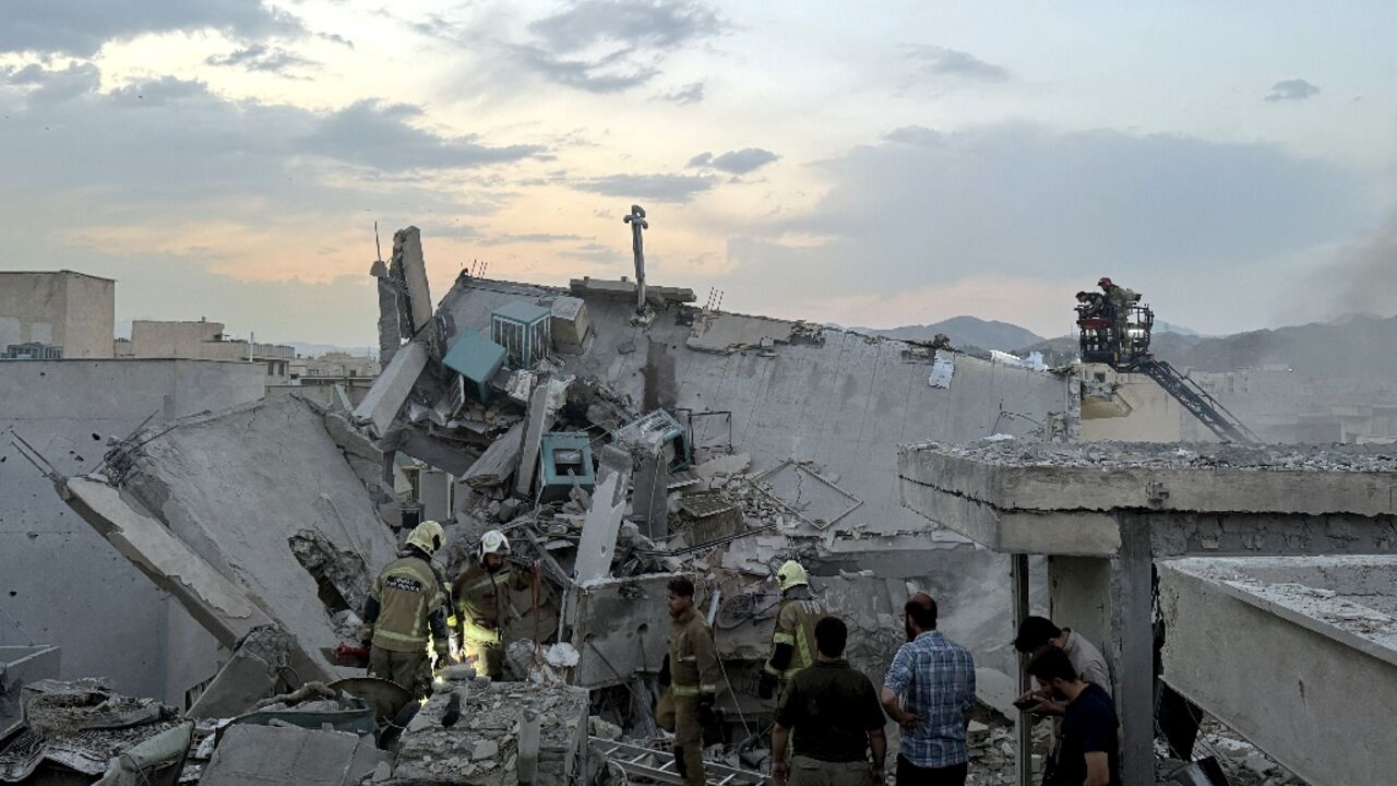First responders clamber over the rubble of a Tehran building hit by an Israeli strike. First responders clamber over the rubble of a Tehran building hit by an Israeli strike.