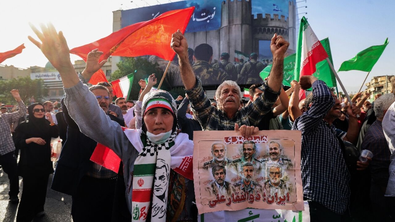 Iranians wave flags and placards during a rally protesting the US attack on Iran in Enghelab Square in Tehran on June 22, 2025 Iranians wave flags and placards during a rally protesting the US attack on Iran in Enghelab Square in Tehran on June 22, 2025