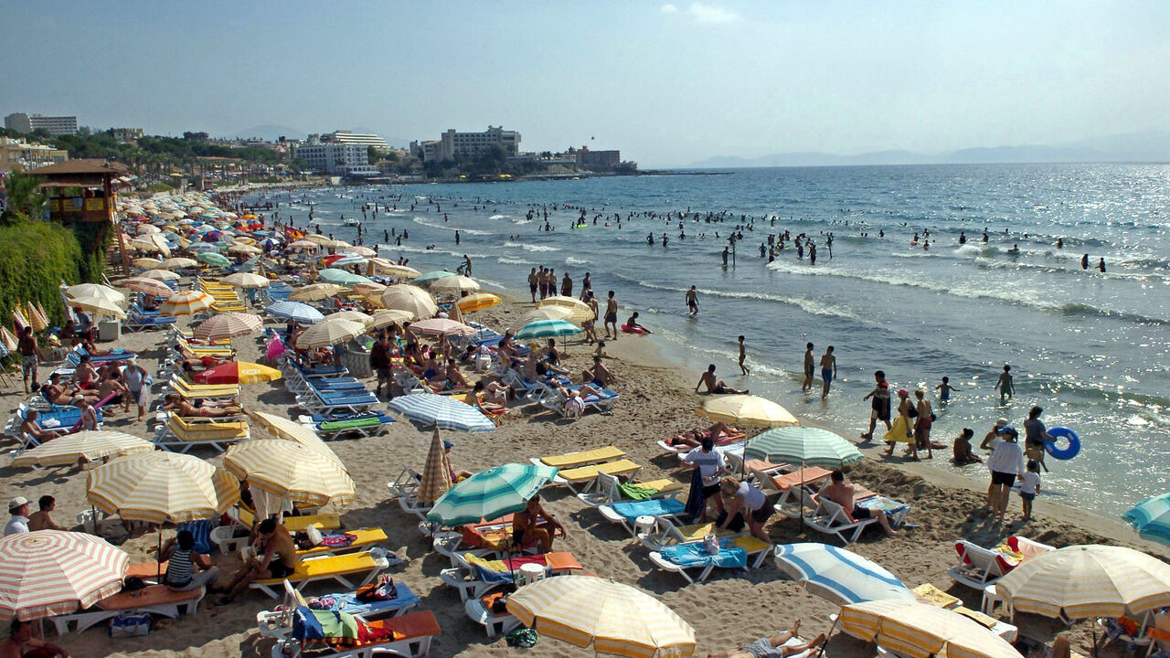 People enjoy the sun and the sea along the Kadinlar Beach of Kusadasi on July 17, 2005.