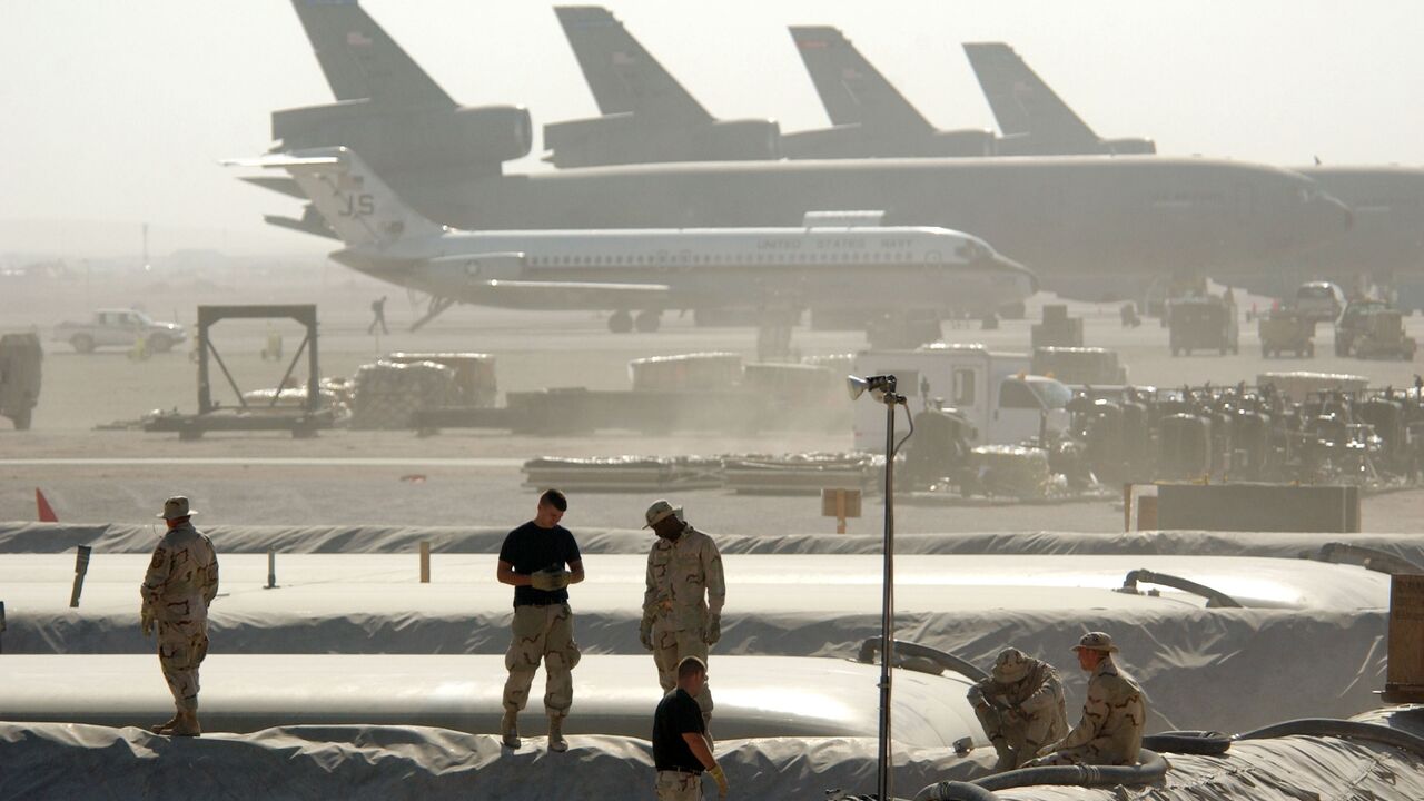 Members of the Petroleum Oils and Lubricants squadron at the 379th Air Expeditionary Wing take a break from replacing a 50,000-gallon fuel bladder in support of Operation Enduring Freedom, on Dec. 30, 2002, in Al Udeid, Qatar.