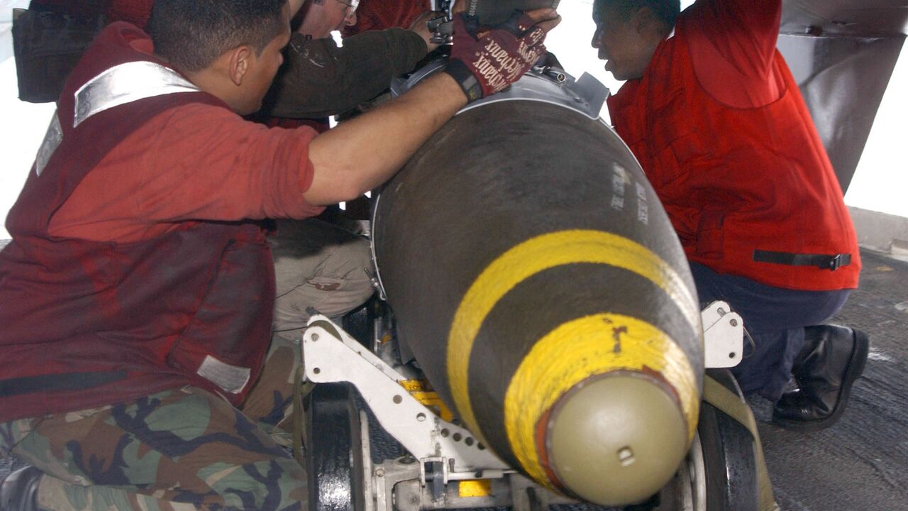 Aviation Ordnancemen assigned to "The Swordsmen" of Fighter Squadron Thirty Two (VF-32) transfer 2,000-pound Joint Directional Attack Munition (JDAMs).