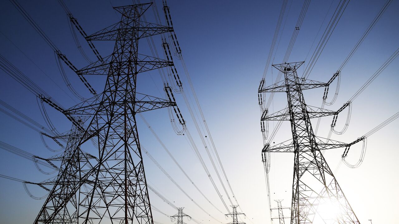 The sun sets behind overhead power lines in Kuwait City as the Kuwaiti Ministry of Electricity requested that citizens ration their electricity usage at peak times due to outages, on June 19, 2024.