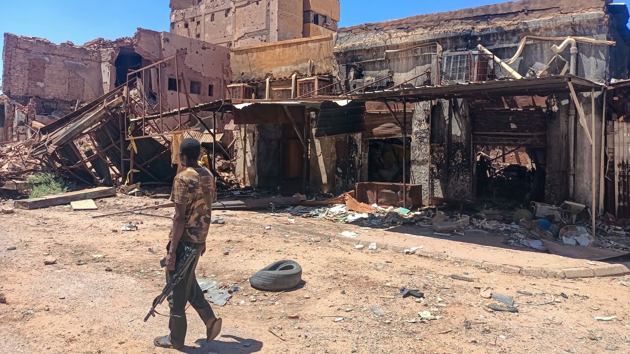 A fighter loyal to the army patrols a market area in Khartoum on March 24, 2025.