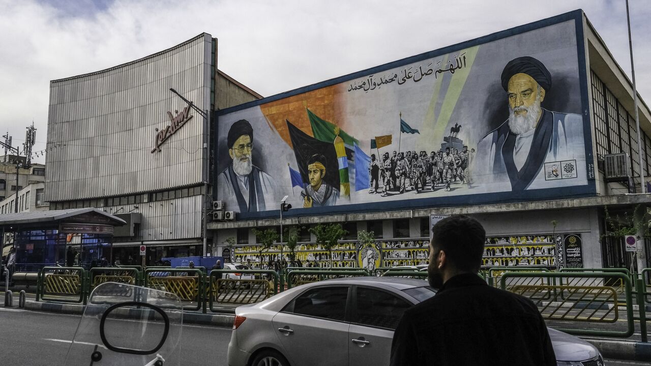 ranians pass by a mural that depicts the two Supreme Leaders of Iran near Enghelab (Revolution) Square in downtown Tehran, Iran on April 8, 2025.