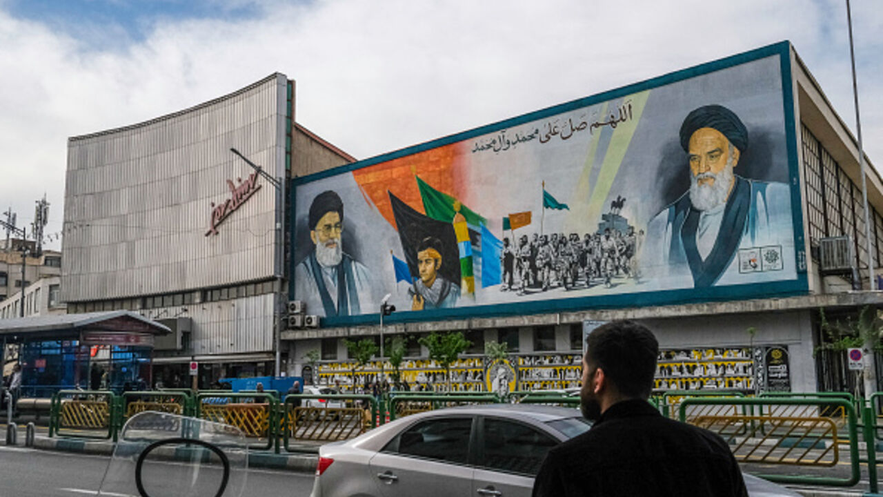Iranians pass by a mural that depicts the two Supreme Leaders of Iran near Enghelab (Revolution) Square in downtown Tehran, Iran on April 8, 2025. (AFP via Getty Images)